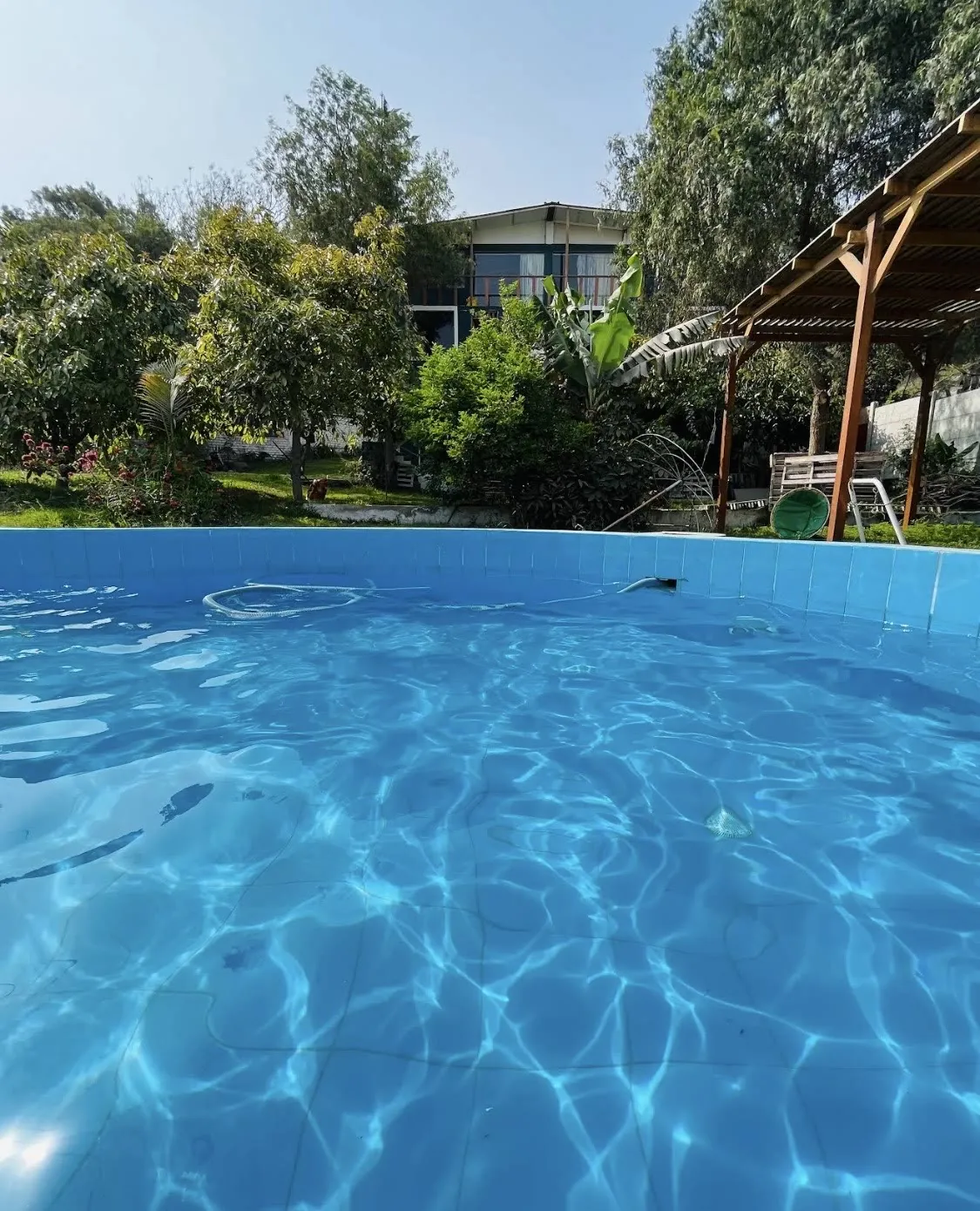 Piscina con agua clara y la casa al fondo
